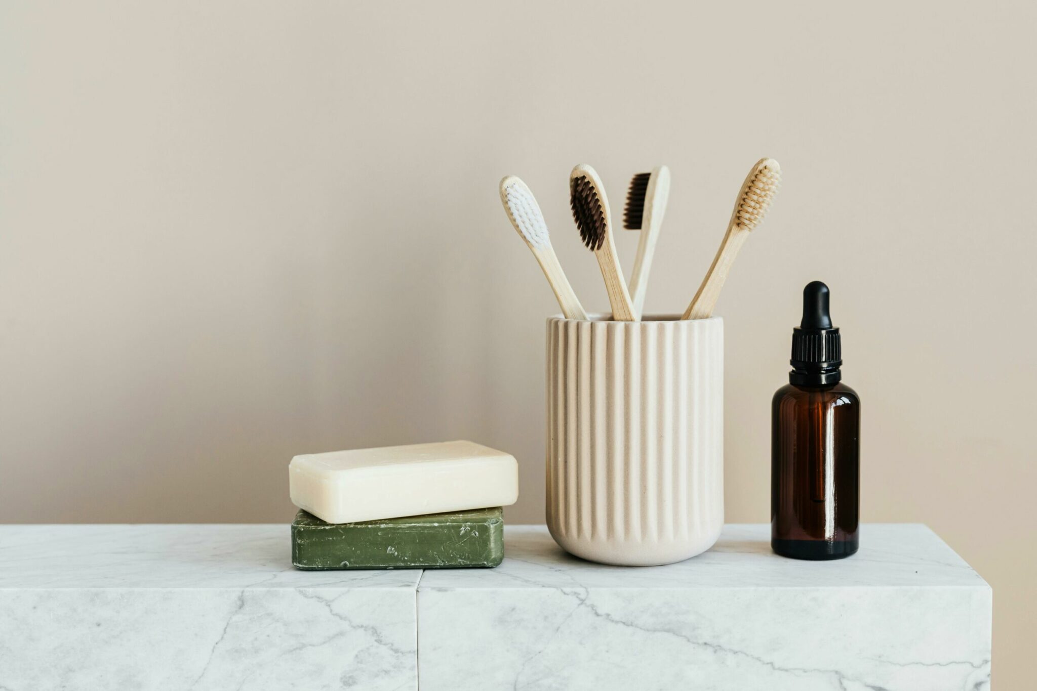 Bamboo toothbrushes next to two bars of soap and a soap dispenser for the personal care products in Wanaka article.