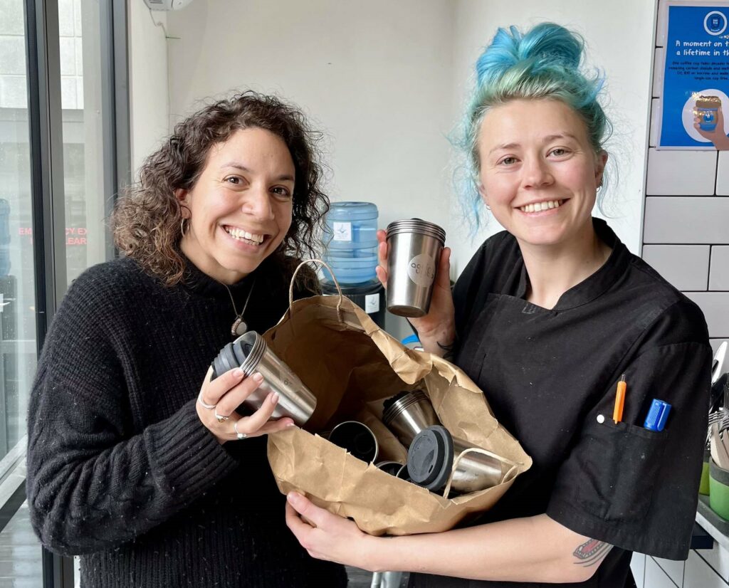 A customer handing over SUCfree cups to a cafe worker.