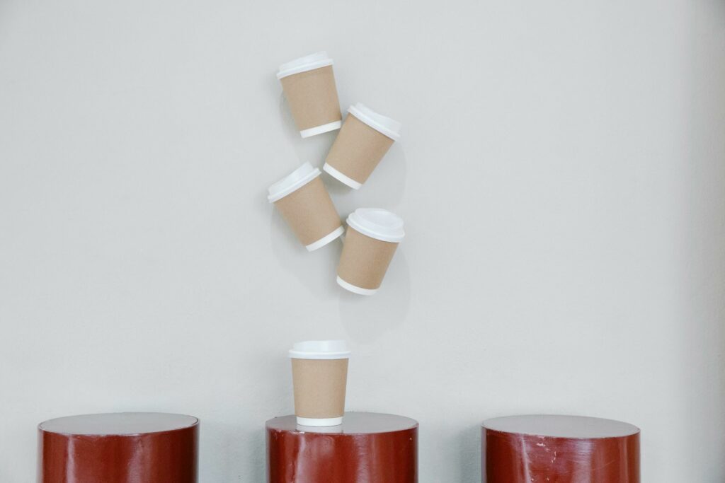 Reusable coffee cups piled up on a bin.