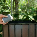 A compostable cup being put into a bin